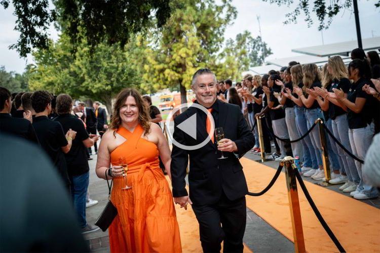 a couple walks the orange carpet at the 橙色 and Black ball